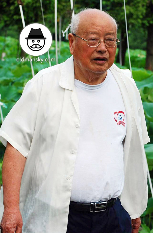 Glasses white hair old man wore white shirt walked by the lotus pond