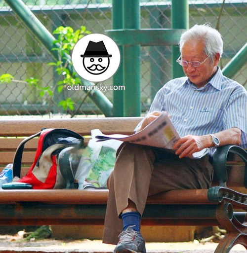 White hair glasses old man was reading newspapers on the park bench_04