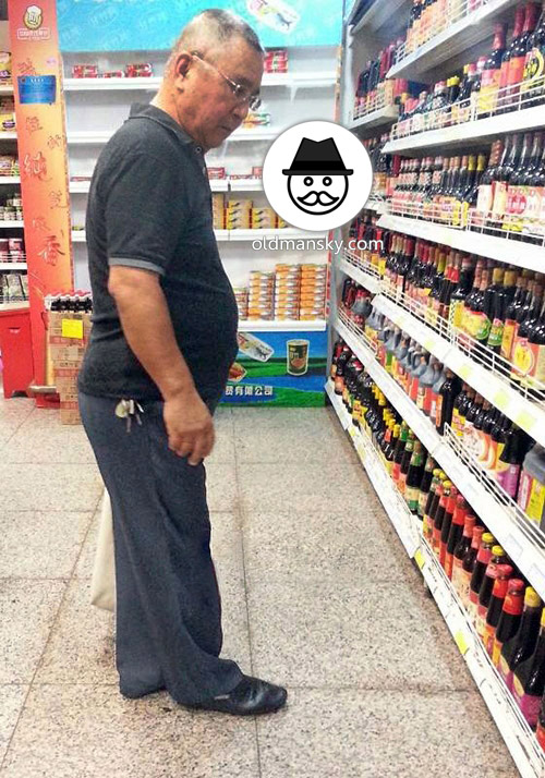 Old daddy wore black polo shirt was shopping in the supermarket