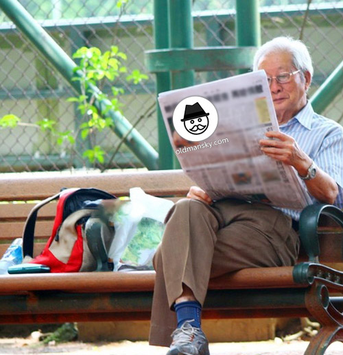 White hair glasses old man was reading newspapers on the park bench_05