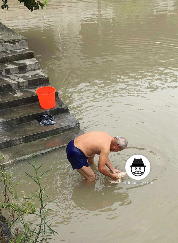 White hair old man wore a brown underwear was washing his head by the river_03