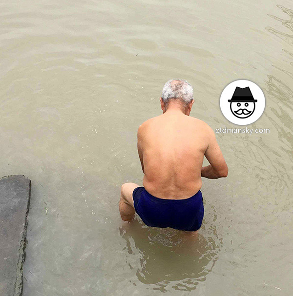 White hair old man wore a brown underwear was washing his head by the river_08