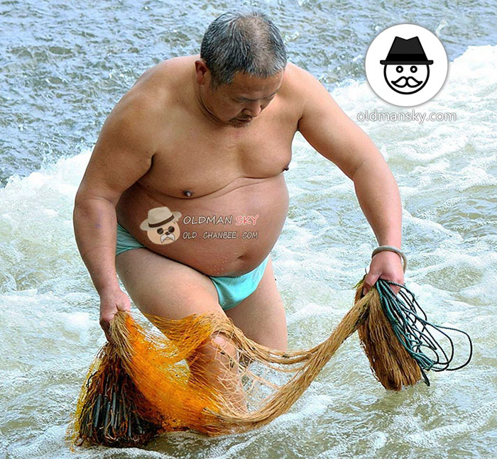 Fat old daddy was fishing with a fishing net by the seaside