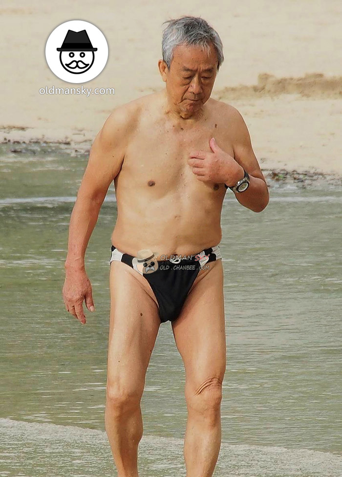 Swimming old man wore a black underwear stood in the water